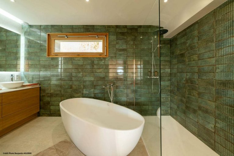 Salle de bain avec baignoire îlot et faïence verte