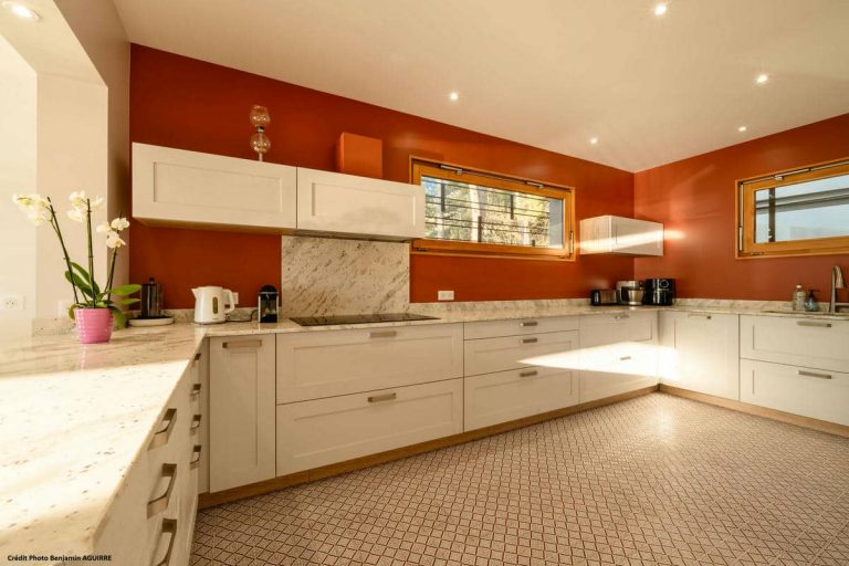 Cuisine contemporaine aux murs orange, entièrement équipée